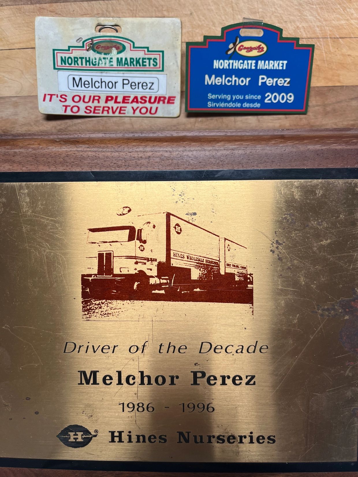 Plaques and badges honoring Melchor Perez for service and achievement in markets and nurseries.