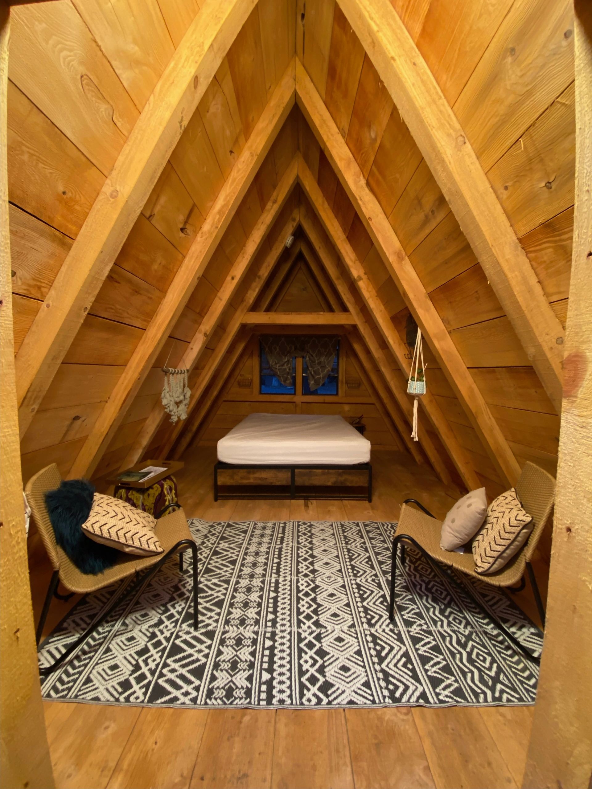 Inside of Bear Bungalow cabin, queen bed, 2 small chairs