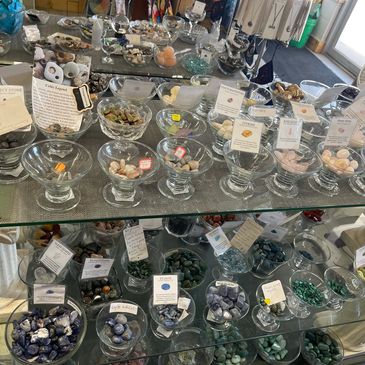 Glass bowls filled with various colorful stones and crystals.