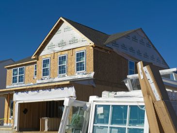 House under construction with blue sky.