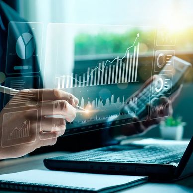 Person analyzing financial data with digital charts on a laptop and smartphone.