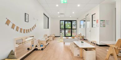 Bright and tidy children's playroom with wooden furniture.