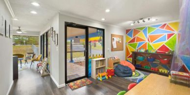 Colorful playroom with geometric wall art and toys.