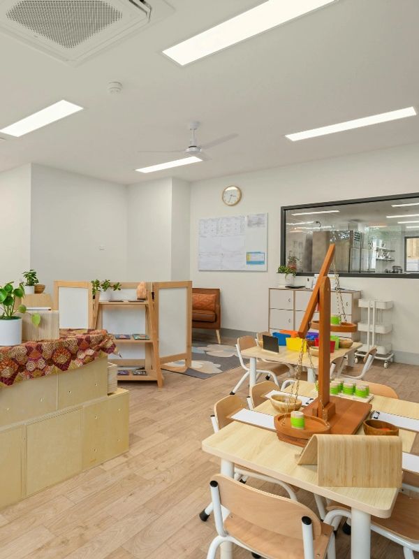 Bright and organized classroom with child-sized furniture and educational tools.