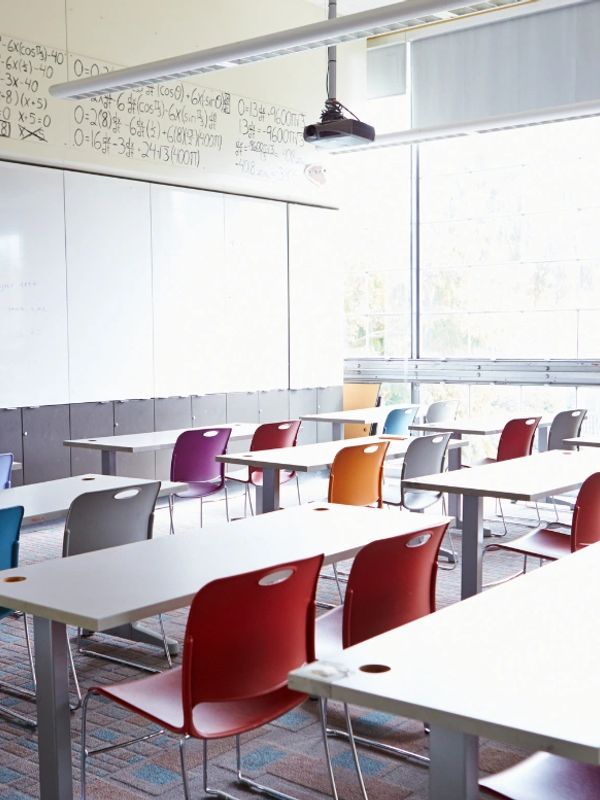Bright classroom with colorful chairs and math equations on the whiteboard.