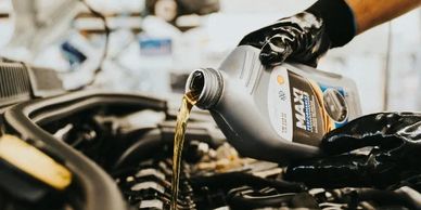 Pouring motor oil into a car engine.