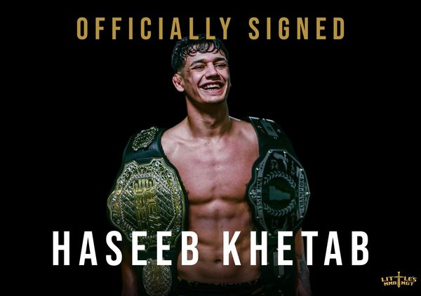 Haseeb Khetab officially signed, proudly holding two championship belts.