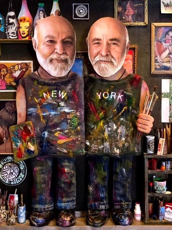 Two artistic figurines with bald heads and white beards, each wearing paint-splattered outfits labeled 'New York'.