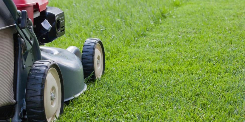 A lawn mower performing regular lawn maintenance cutting grass in Richmond Hill, GA 31324.