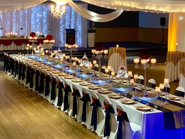 Elegant banquet hall with long tables set for a formal event.
