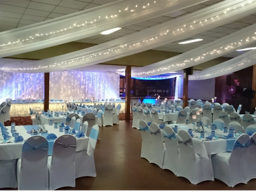 Elegant banquet hall with white and blue decor for a special event.