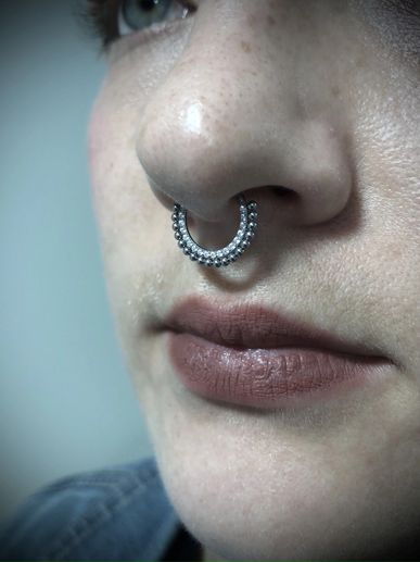Close-up of a nose with a decorative septum ring.
