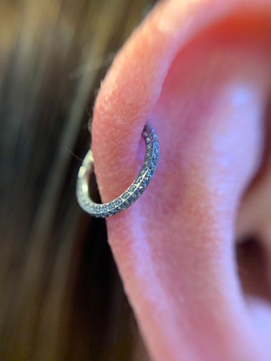 Close-up of an ear with a sparkling hoop earring.