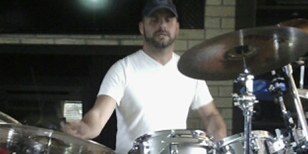Damon Navari drumming at home in his livingroom.