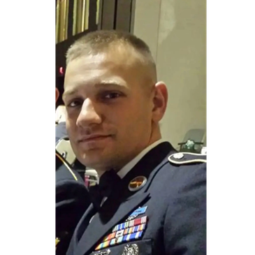 Young man in a formal military uniform with medals and ribbons.