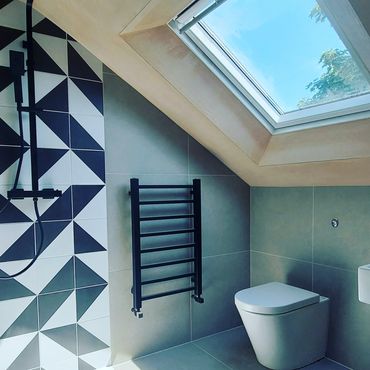 Modern bathroom with skylight and geometric tiles.