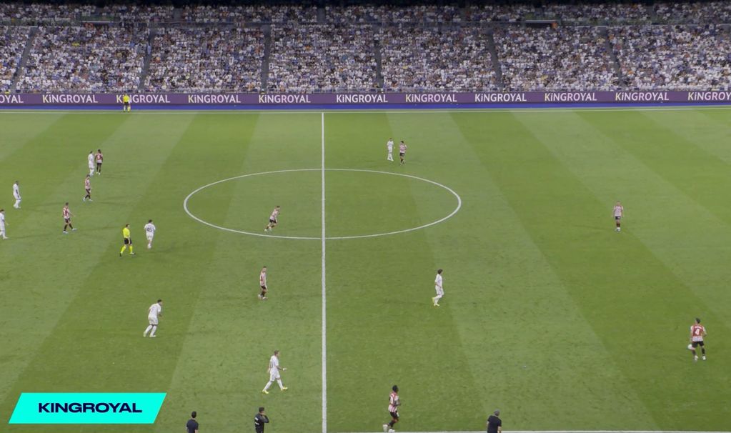 Soccer match underway with players on the field and KingRoyal ads around the stadium.