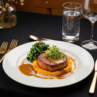 Upscale plant-based entrée with plant-based steak, mashed sweet potatoes and spinach. 