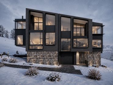 Modern house with large windows in snowy mountain setting at dusk.