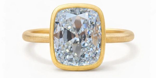 Elegant gold ring with a large cushion-cut diamond.