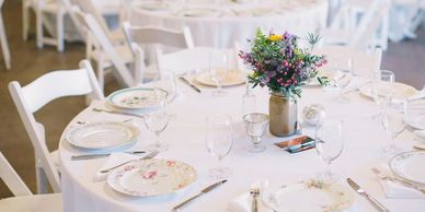 Elegant round table set for a formal event with floral centerpiece.