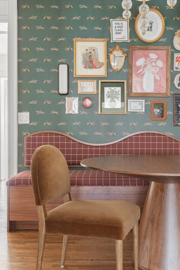 Cozy dining nook with vintage gallery wall and upholstered seating.