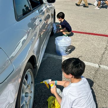 Chase Ashton and two sons cleaning the Fine Spec JDM Nissan R33 GT-R at COTA Super Lap Battle.