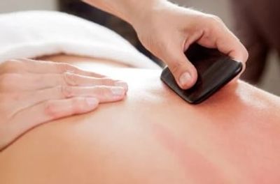 Gua Sha being performed on a back