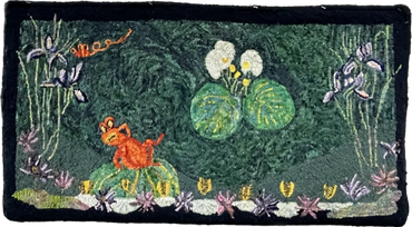 Embroidered patch with flowers and a small orange animal on green fabric.