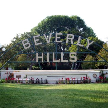 Beverly Hills sign in a park with greenery.
