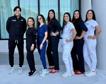 A group of seven healthcare professionals standing together outdoors.