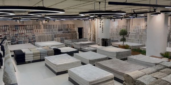 Modern carpet showroom with various rugs displayed.
