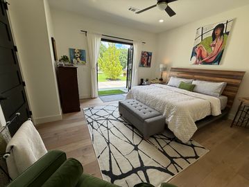 Modern bedroom with open doors to a garden.