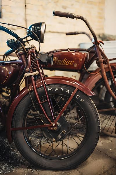 Close-up of a vintage Indian motorcycle's front wheel and headlight.
