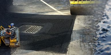 Worker paving a road with asphalt machine.