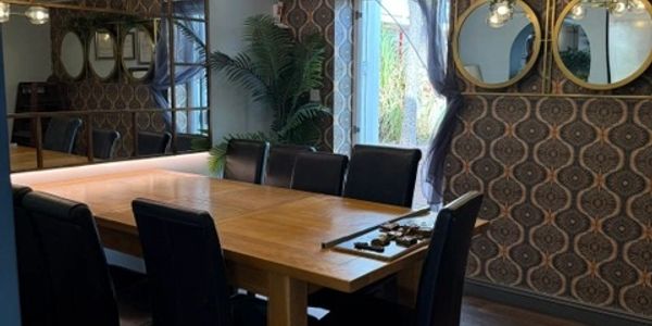 Cozy dining room with wooden table and black chairs.