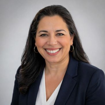 Smiling woman with long dark hair in business attire.