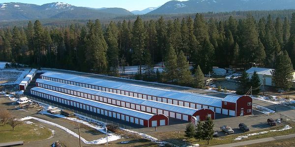 Long storage buildings in a snowy forested area.
