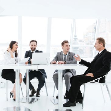 Happy office team both male and female having a meeting at a table