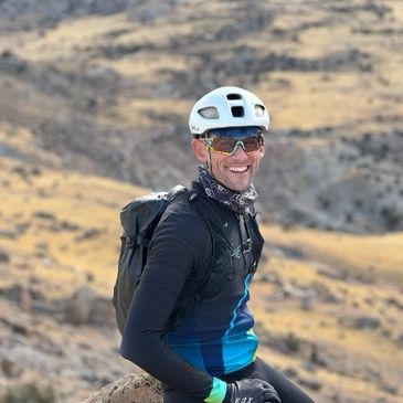 Cyclist sitting on a rock outdoors