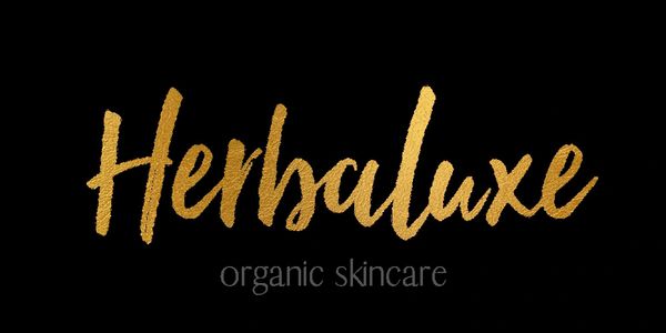 Elegant gold text logo for Herbaluxe organic skincare on black background.