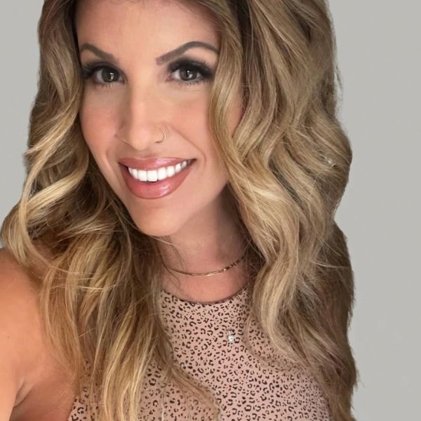 Smiling woman with wavy blonde hair and a nose ring.