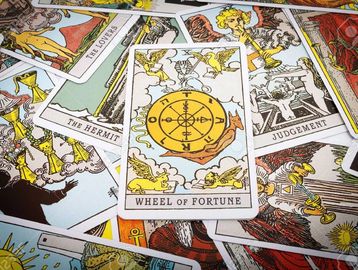 A close-up of tarot cards with Wheel of Fortune in focus.