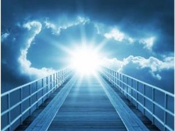 A bright light at the end of a bridge under a cloudy sky.