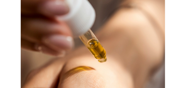 oil dropper of natural skin care treatment being tested on skin