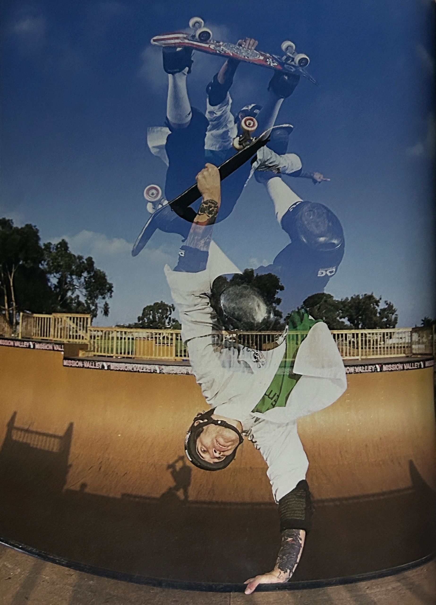 Skateboarder performing an aerial trick at a skatepark bowl.