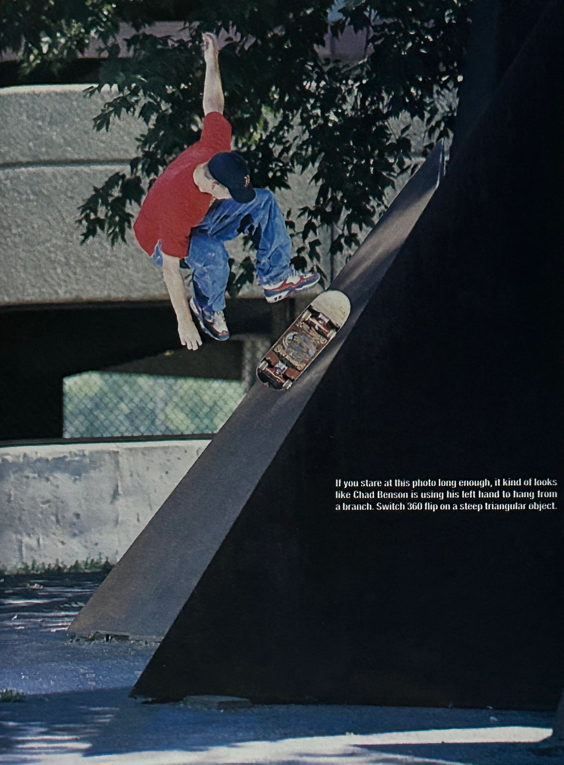 Skateboarder performing a switch 360 flip on a steep triangular ramp.