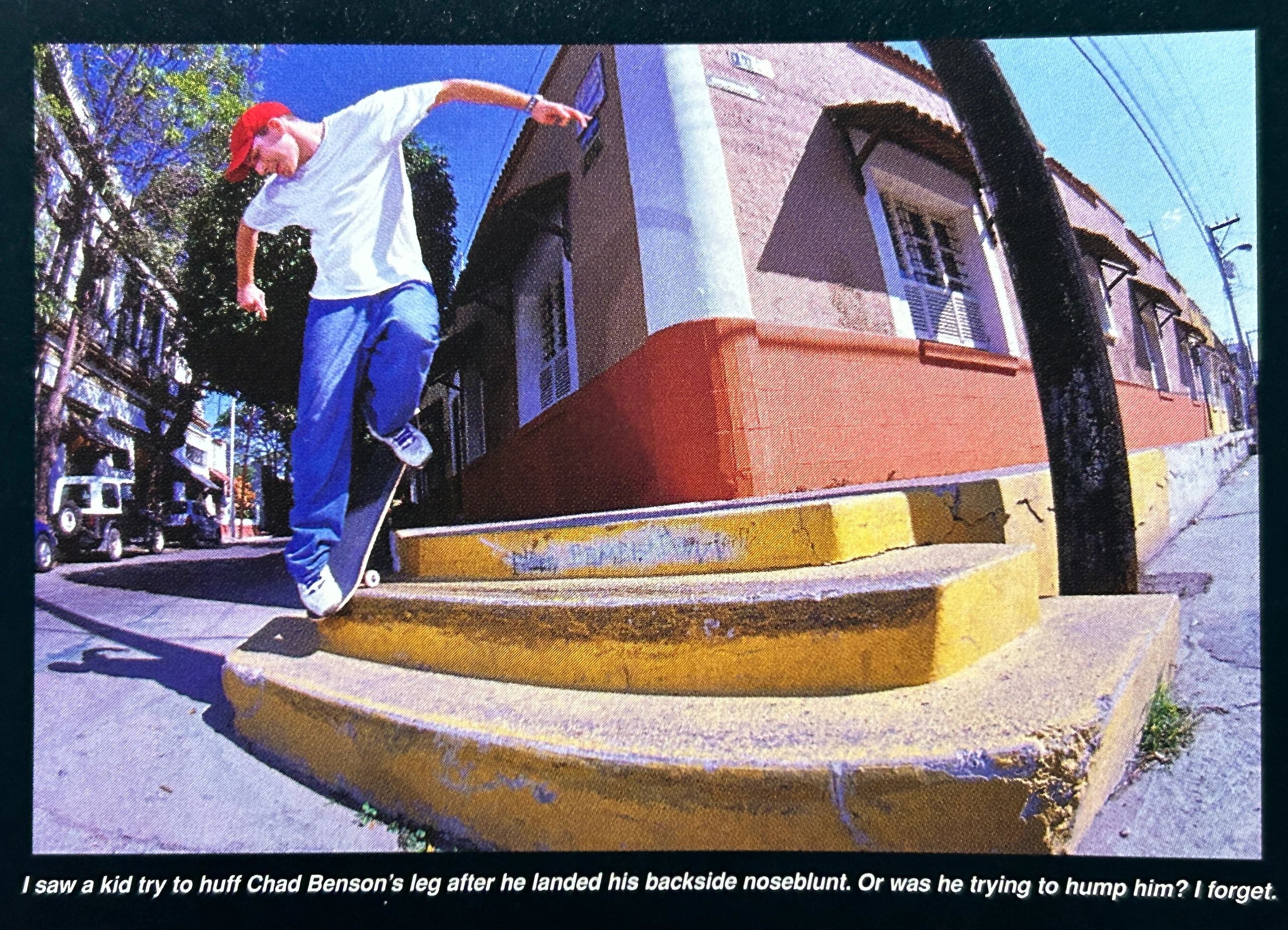Skateboarder performing a backside noseblunt on yellow steps in a sunny urban area.