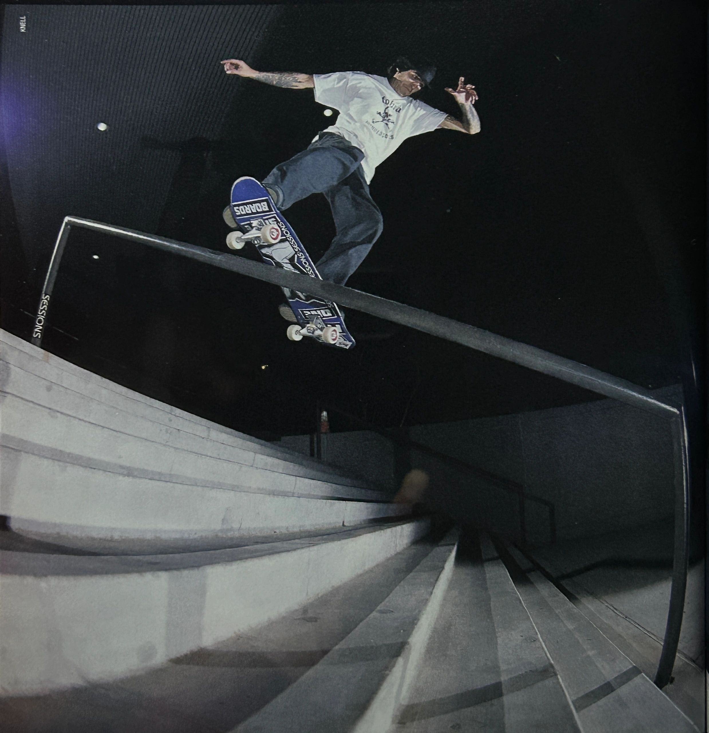 Skateboarder grinding a rail at night, captured from a low angle.