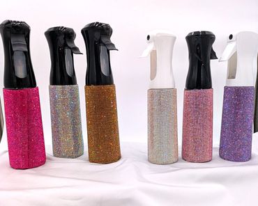 Six sparkling spray bottles in black and white with glittery covers.